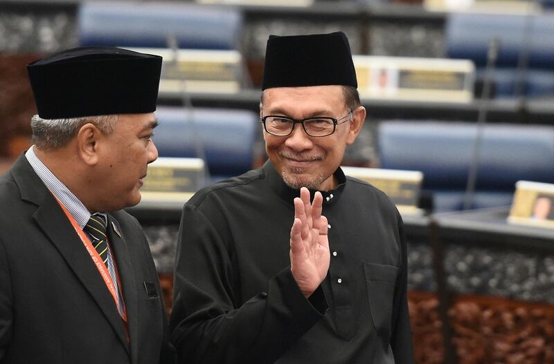 Malaysia's People's Justice Party president and leader of the Pakatan Harapan coalition Anwar Ibrahim (R) waves before taking an oath as a member of the parliament during a swearing-in ceremony at the Parliament House in Kuala Lumpur on October 15, 2018. / AFP / Mohd RASFAN
