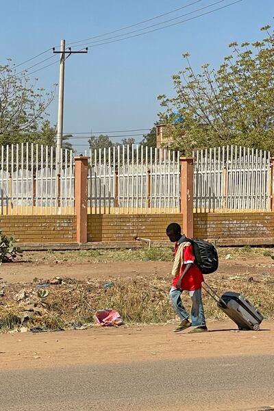 A boy displaced by the conflict in Sudan walks with his belongings along a road in Wad Madani, the capital of Al Gezira state. AFP