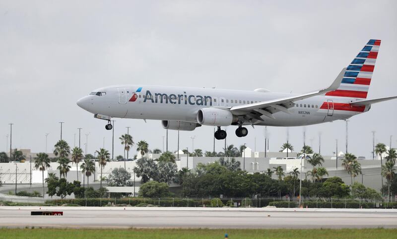An American Airlines Boeing 737-823 lands at Miami International Airport, Monday, July 27, 2020, in Miami. American Airlines is dropping flights to 15 U.S. cities in October, when a federal requirement to serve those communities expires. American said Thursday, Aug. 20 that it will consider other changes unless the federal government provides more money to the embattled airline industry. (AP Photo/Wilfredo Lee)