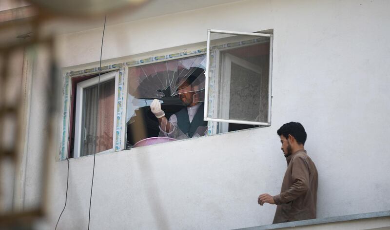 A man removes broken glass after a rocket hit the roof of his house, in Kabul, Afghanistan.  EPA