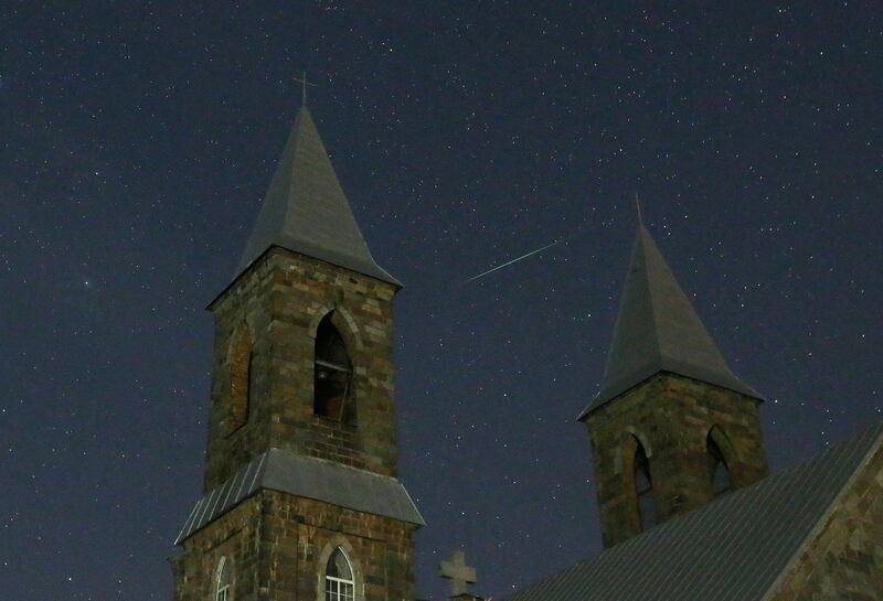 epa06141525 A meteor of the Perseids meteor shower burns up in the atmosphere behind a Catholic church near the village of Rubezhevichi, some 50 km from Minsk, Belarus, late 12 August 2017. The Perseid meteor shower occurs every year in August when the Earth passes through debris and dust of the Swift-Tuttle comet.  EPA/TATYANA ZENKOVICH