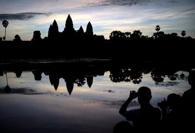 This photo taken on November 8, 2014 shows tourists taking photos of the Angkor Wat temple complex at sunrise in Cambodia's Angkor National Park, Siem Reap province. Angkor is described by UNESCO as "one of the most important archaeological sites in Southeast Asia" and contains the ruins of the different capitals of the Khmer Empire from the 9th to the 15th centuries.   AFP PHOTO/ ALEX OGLE / AFP PHOTO / Alex Ogle