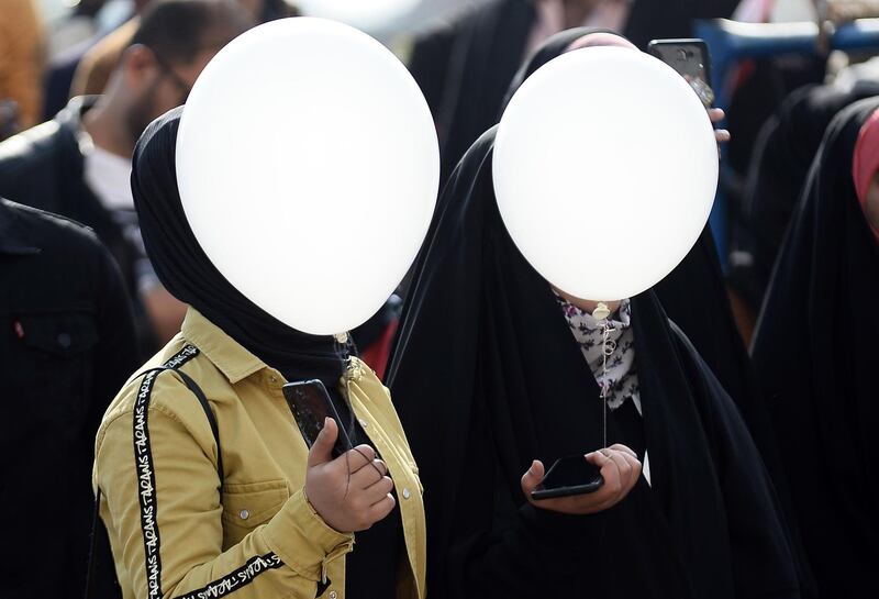 Iraqi students hold white ballons as they take part in an anti-government demonstration in the central city of Najaf. AFP