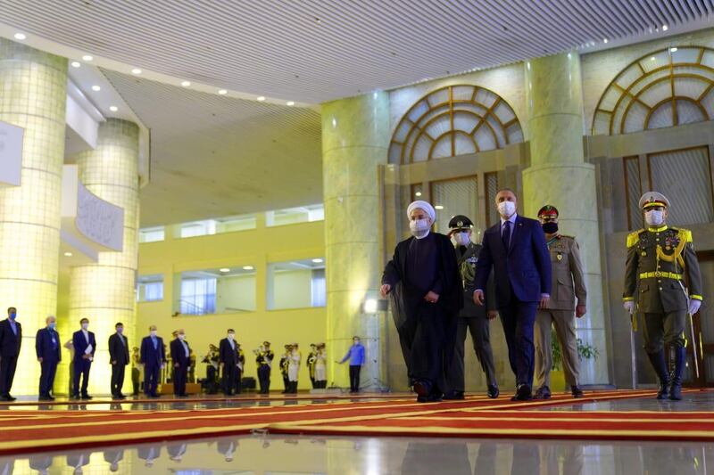 Iranian President Hassan Rouhani welcomes the Iraqi Prime Minister, Mustafa Al Kadhimi, as they wear protective masks, in Tehran, Iran.  Reuters
