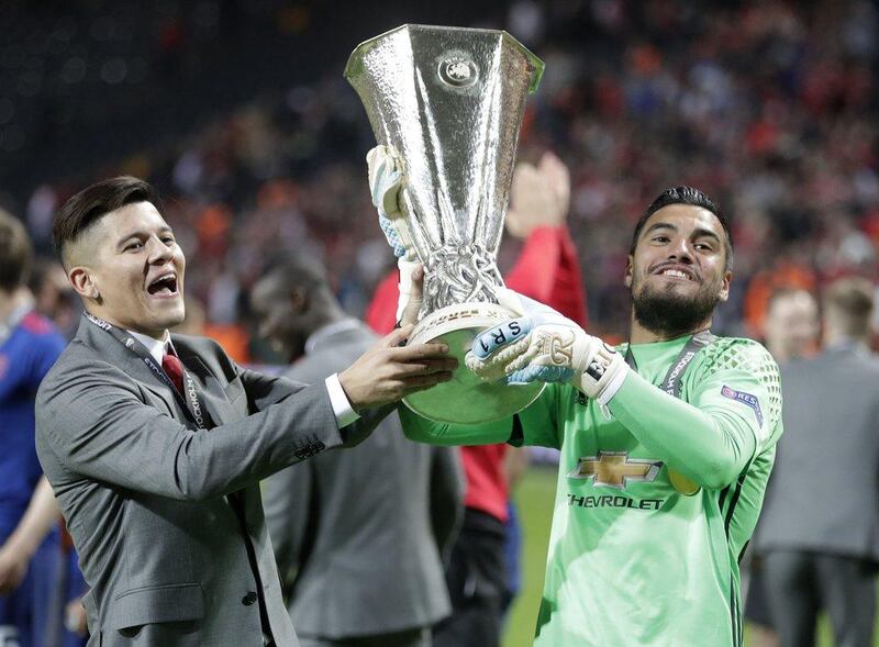 Sergio Romero, right, lifts the Europa League trophy with injured Manchester United defender Marcos Rojo. Michael Sohn / AP Photo