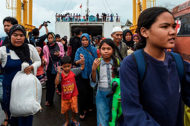 Residents disembark from a ferry at the port after being evacuated from Sebesi Island, in Bakauheni in Lampung province on December 26, 2018, after the December 22 tsunami - caused by activity at a volcano known as the "child" of Krakatoa - hit the west coast of Indonesia's Java island. Indonesian search and rescue teams on December 26 plucked stranded residents from remote islands and pushed into isolated communities desperate for aid in the aftermath of a volcano-triggered tsunami that killed over 400. / AFP / MOHD RASFAN

