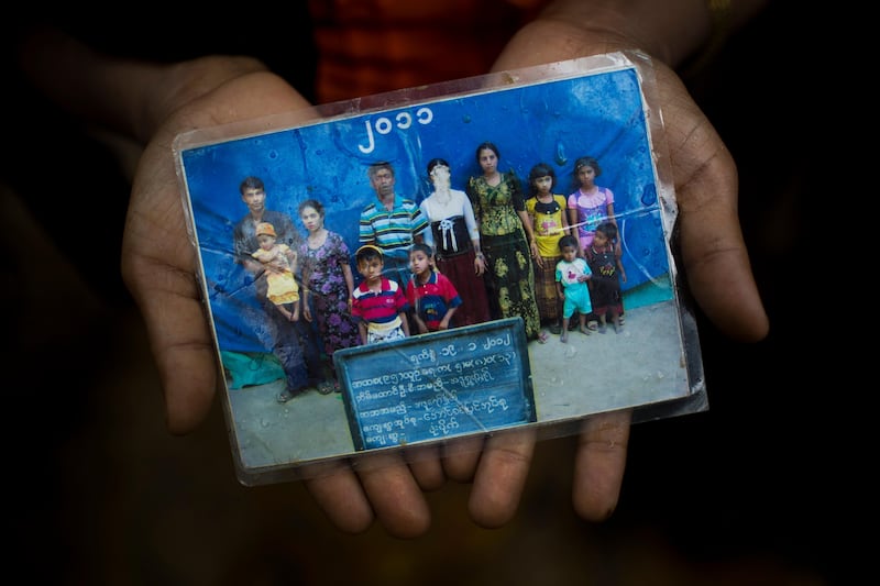 Rohingya Mubarak Begum, who crossed over from Myanmar into Bangladesh, holds a photograph of her family members, in Kutupalong, Bangladesh, Begum says the government took pictures of Rohingya families annually to track their numbers. Bernat Armangue / AP Photo