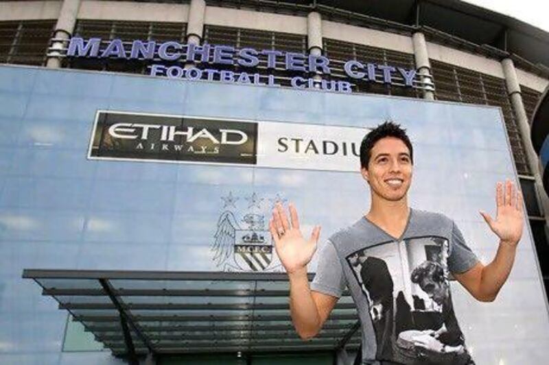 Samir Nasri gestures outside at the Etihad Stadium, Manchester, England the home ground of Manchester City soccer team Wednesday Aug. 24, 2011 where Nasri is expected to become a Manchester City player later Wednesday. Arsenal agreed to sell Samir Nasri to Manchester City on Tuesday, paving the way for the midfielder to join an expensively assembled squad already filled with attacking talent. The 24-year-old France international was due to travel to Manchester for a medical examination on Tuesday, Arsenal said before the north London team flew to Italy for a Champions League playoff against Udinese. (AP Photo/Peter Byrne/PA Wire) UNITED KINGDOM OUT NO SALES NO ARCHIVE *** Local Caption *** Britain Nasri Manchester City.JPEG-0fd3d.jpg