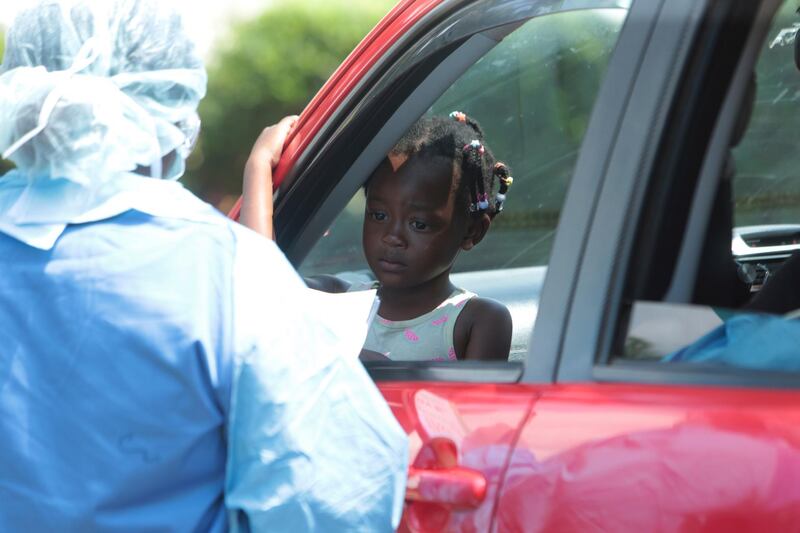 A child who has a high temperature has her details recorded by a health worker at a public hospital, in Harare, Zimbabwe. AP Photo