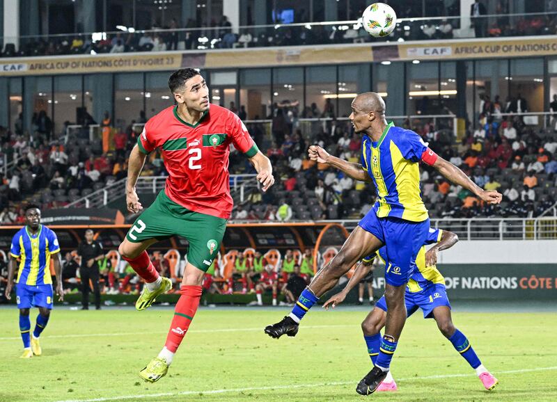 Morocco defender Achraf Hakimi heads the ball in front of Tanzania midfielder Himid Mao. AFP