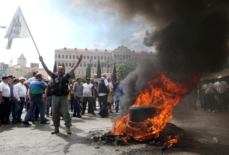 Ex-soldier gestures near burning tires as he takes part in a protest against cuts to their benefits outside the government headquarters in dowtown Beirut, Lebanon May 10, 2019. REUTERS/Mohamed Azakir