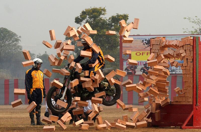 A 'Tornadoes' motorcycle display team rider smashes through a wall of bricks in Chennai. Arun Sankar / AFP Photo