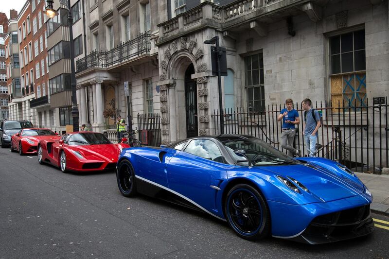 LONDON, ENGLAND - JULY 23: Ferraris are pictured behind a blue Dubai-registered Pagani Huayra on July 23, 2015 in London, England. London has become known in recent years for a proliferation of foreign cars worth hundreds of thousands of pounds with tourists and car spotters stopping to admire the vehicles. (Photo by Carl Court/Getty Images)