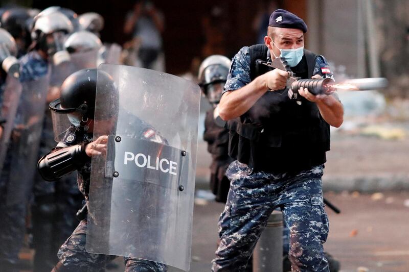 A member of Lebanese riot police fires a weapon during anti-government protests that have been ignited by a massive explosion in Beirut, Lebanon August 10, 2020. REUTERS/Thaier Al-Sudani     TPX IMAGES OF THE DAY