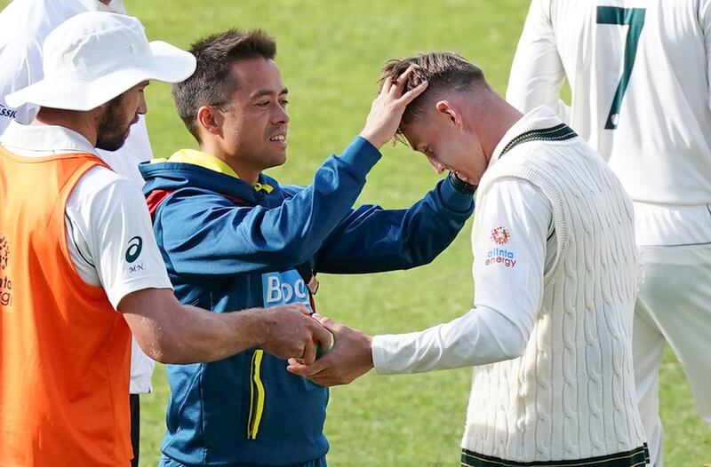 Marnus Labuschagne is checked by the team doctor for concussion after he was struck on the helmet in Adelaide. EPA