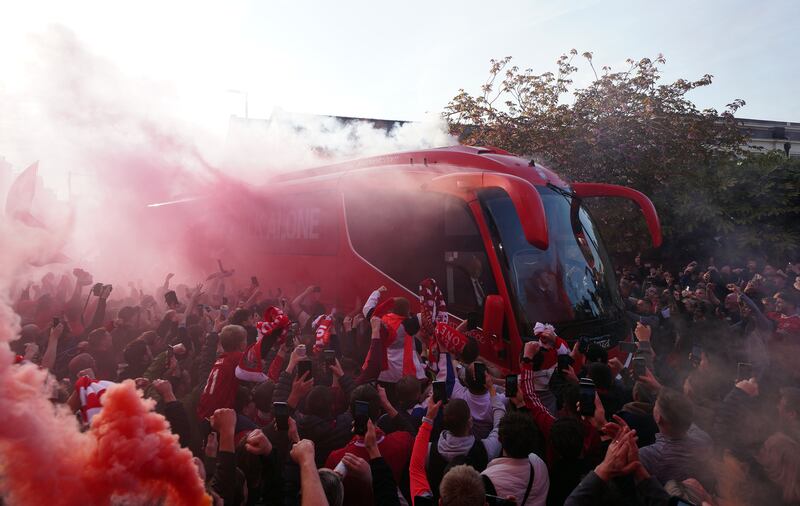 Liverpool fans greet their team bus. PA