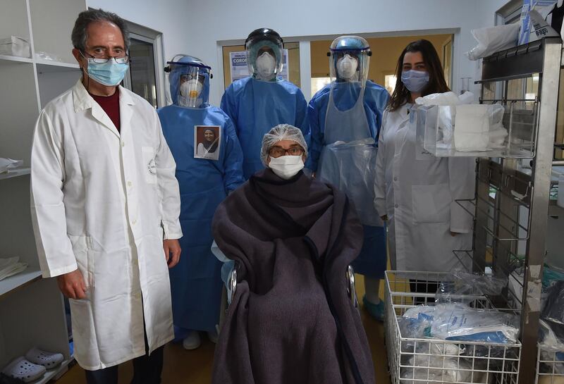 Chief physician Mohamed Besbes (left), Amira Jamoussi (right) and members of the medical staff surround a patient who recovered from the coronavirus, before being released from the Abderrahmane Memmi hospital, in the city of Ariana north of the Tunisian capital Tunis. AFP