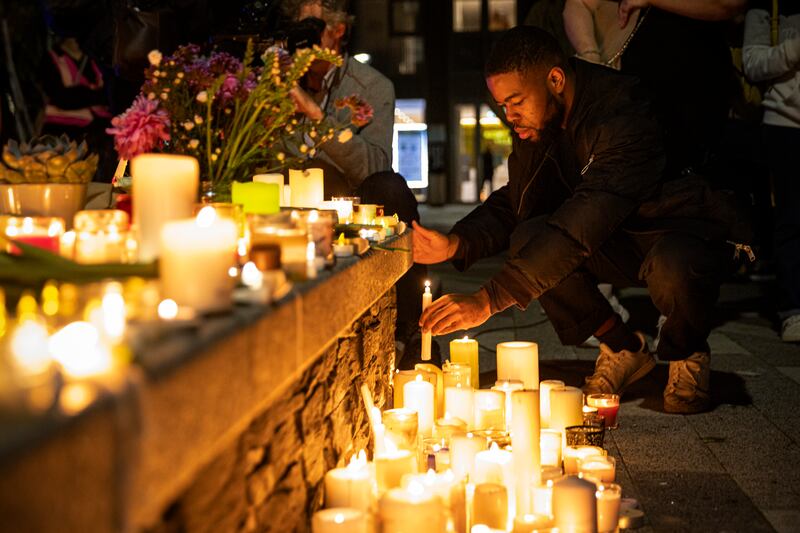 A man lights a candle in Pegler Square. Getty Images