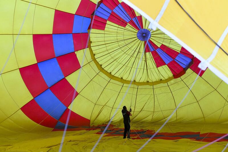 A balloon pilot is seen standing inside a hot air balloon as he prepares for take off during the Canberra International Balloon Festival. Lukas Coch / EPA