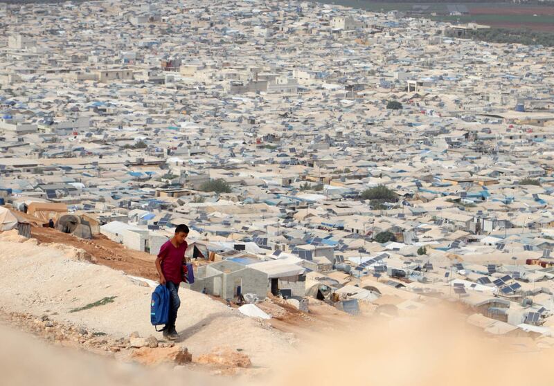 (FILES) In this file photo taken on October 28, 2020, a young displaced Syrian returns from school to an overcrowded displacement camp near the village of Qah near the Turkish border in the northwestern Idlib province, during the novel coronavirus pandemic crisis.   - 
 / AFP / Ahmad al-ATRASH
