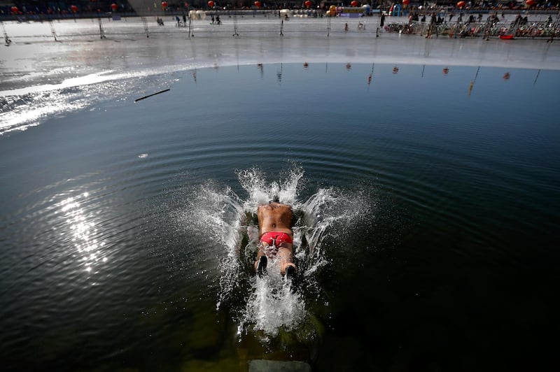 A man dives into the half-frozen water at the Shichahai Lake in Beijing. Andy Wong / AP Photo