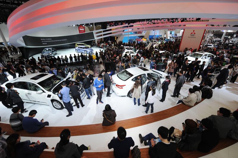 Visitors look at cars on the opening day of the Shanghai auto show on April 21, 2013. Chinese buyers swarmed around hundreds of vehicles at the Shanghai auto show at its opening highlighting the importance of the world's largest car market to manufacturers.  AFP PHOTO/Peter PARKS
 *** Local Caption ***  958117-01-08.jpg