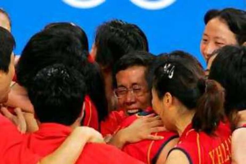 Chinese team celebrates its victory at the end of the gold medal volleyball match against Russia at the Olympic Games, 28 August 2004 at Peace and Friendship Stadium in Athens. China won 3 - 2 (28-30, 25-27, 25-20, 25-23, 15-12). AFP PHOTO DAMIEN MEYER