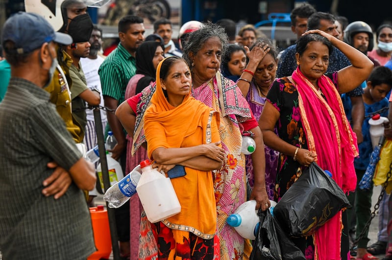 People queue up to buy kerosene for domestic use at a supply station in Colombo on Tuesday. AFP