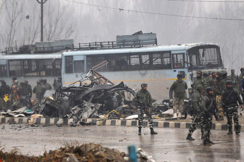 SRINAGAR, INDIA - FEBRUARY 14: Security forces near the damaged vehicles at Lethpora on the Jammu-Srinagar highway, on February 14, 2019 in Srinagar, India. At least 30 CRPF jawans were killed and many others injured in an improvised explosive device (IED) blast at Lethpora. Police sources say that the attack was likely carried out by a suicide bomber, who rammed an explosive-laden car into the CRPF bus. The bus was part of an army convoy coming from Jammu to Srinagar. (Photo by Waseem Andrabi/Hindustan Times via Getty Images)