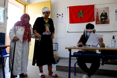 A Moroccan woman guides her mother Zoubida Abaouch to cast her ballot inside a polling station in Casablanca, Morocco on Wednesday.