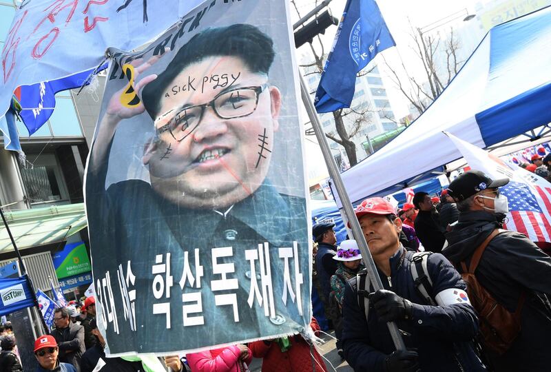 A South Korean pro-US demonstrator holds a banner showing a defaced photo of North Korean leader Kim Jong-un during a rally denouncing the government's dovish approaches and policies on North Korea, in Seoul. AFP