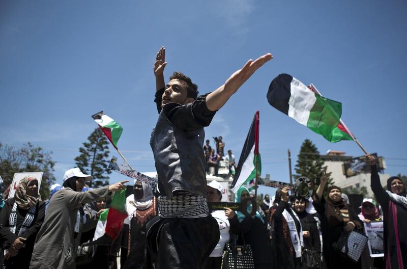 Palestinians wave their flags during a rally in Gaza to commemorate the displacement of Palestinians who either fled or were driven out of their homes after the 1948 war and creation of Israel.  Mohammed Abed / AFP