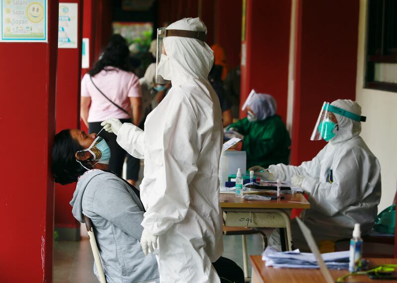 A healthcare worker takes a swab sample to test for Covid-19, during mass testing at a school in Jakarta, Indonesia.