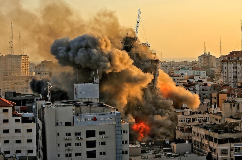 Smoke and flames rise from Al Sharouk tower, as it collapses after being hit by an Israeli air strike in Gaza City. AFP