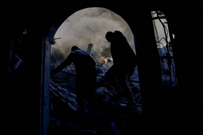 Palestinians walk amid the rubble of buildings destroyed by an Israeli strike, in Khan Younis. Reuters