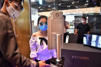People stand in front of facial recognition software before entering the Icon Siam luxury shopping mall as it reopened after restrictions to halt the spread of the COVID-19 coronavirus were lifted in Bangkok on May 17, 2020.  / AFP / Lillian SUWANRUMPHA
