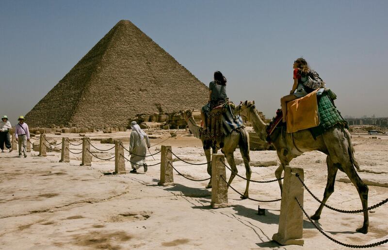 Tourists ride camels during a visit to the Giza Pyramids, near Cairo, Egypt two days after a tour bus struck an improvised explosive device near the site, wounding more than a dozen foreign tourists.  AP Photo