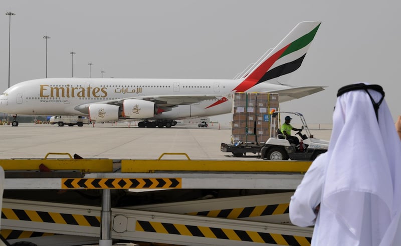 (FILES) In this file photo taken on March 2, 2020 medical equipment and coronavirus testing kits provided bt the World Health Organisation are pictured passing by an Emirates airlines Airbus A380-861, at the al-Maktum International airport in Dubai, as it is prepared to be delivered to Iran with a United Arab Emirates military transport plane.

 Emirates airline has cut a tenth of its workforce during the novel coronavirus pandemic in layoffs that could rise to 15 percent, or 9,000 jobs, its president said, according to a report today.  / AFP / KARIM SAHIB

