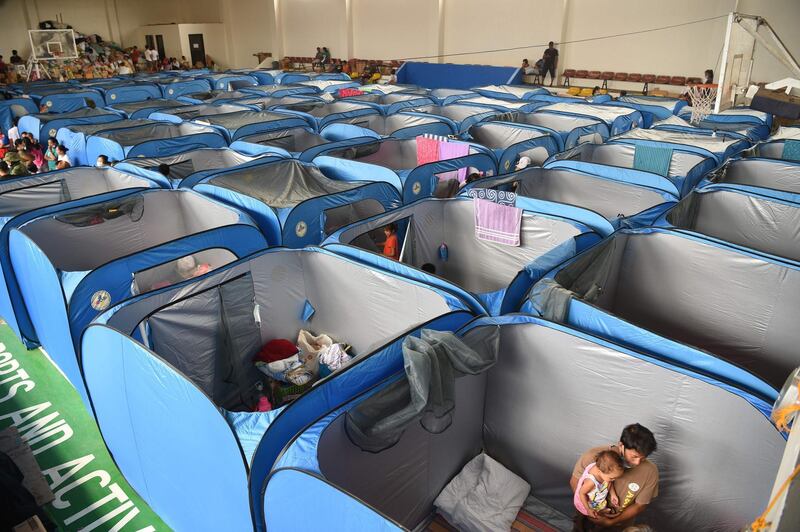Residents settle into indoor tents at an evacuation centre in Tagaytay City. AFP
