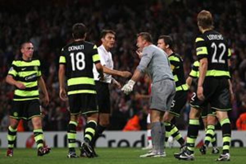 Celtic players surround referee Manuel Enrique Mejuto Gonzalez after his penalty decision.