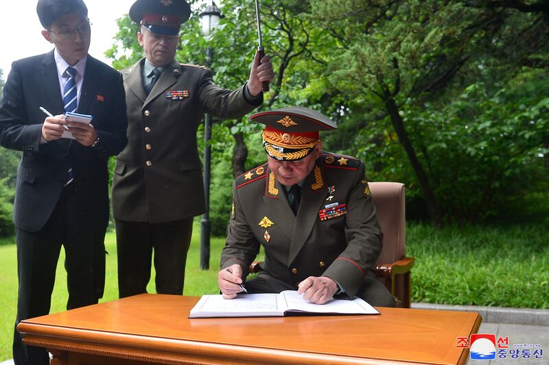 Mr Shoigu signs a guest book during a visit to Mangyongdae. Reuters