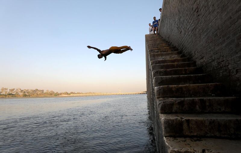 An Egyptian boy jumps into the water to cool off on a hot and humid day in Cairo, Egypt.  Reuters