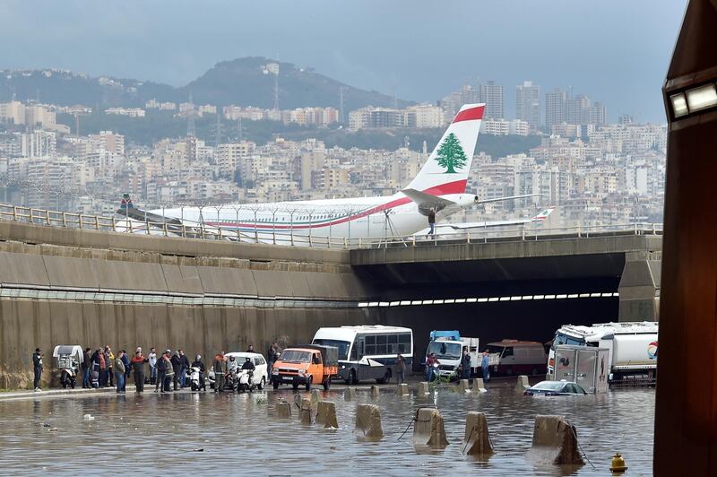 A Middle East Airlines (MEA) plane lands at the airport as vehicles are submerged in water after a heavy downpour on the main road near Rafic Hariri International Airport at the southern entrance of Beirut.  EPA