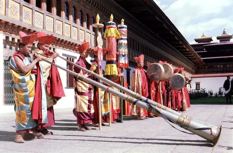 Monks play ceremonial instruments in June 1991 to announce the arrival of King Jigme Singye Wangchuck of Bhutan at the Great Chamber of the Golden Throne in Thimphu to celebrate the 25th anniversary of his rule. Reuters