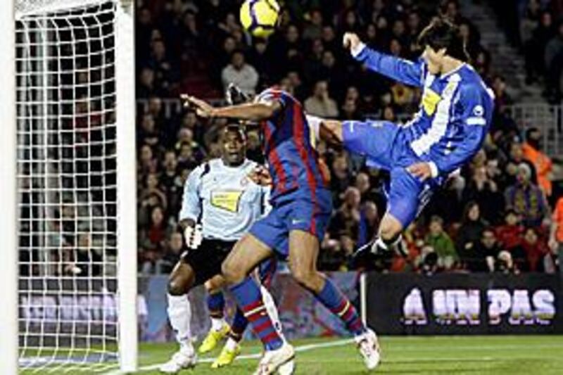 Espanyol's Facundo Roncaglia, right, clears the ball as Barca's Thierry Henry closes in on goal.