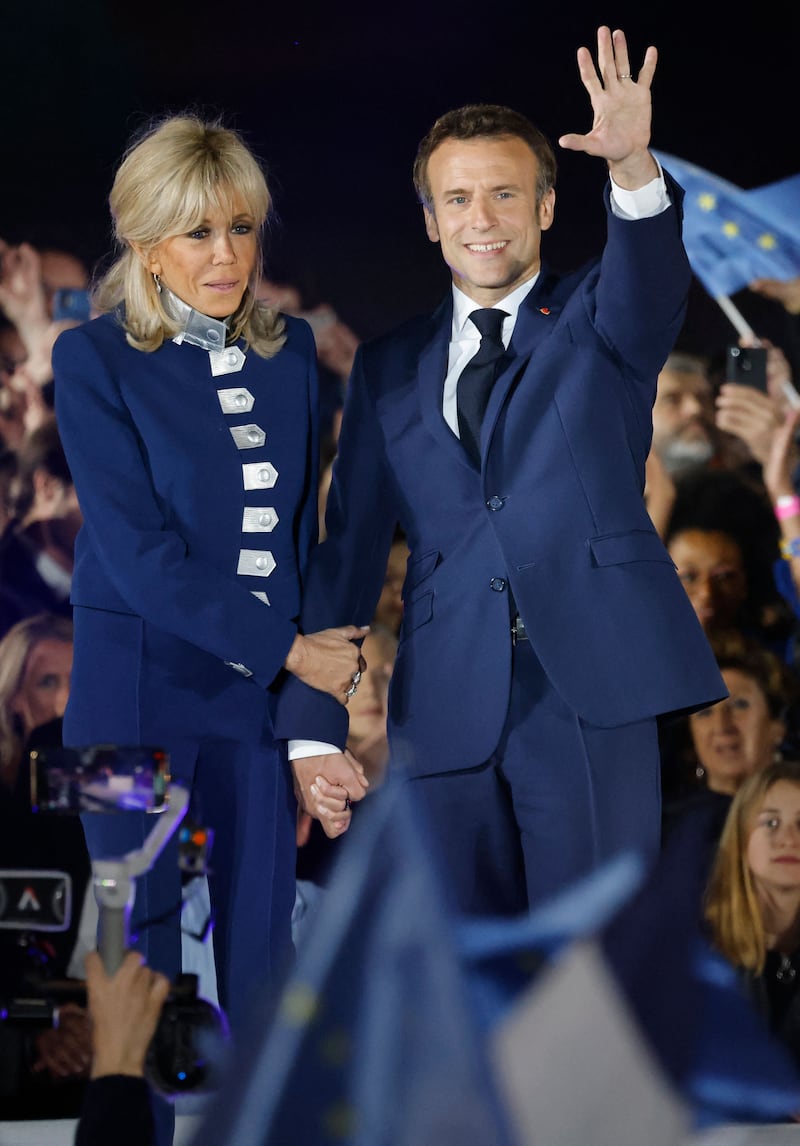 Brigitte, wearing a blue military-style jacket with silver buttons and blue trousers, shortly after her husband Emmanuel Macron's presidential re-election victory on April 24, 2022. AFP