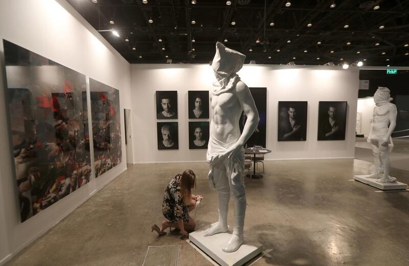 A worker adjusts a statue at the Art Dubai exhibition. Karim Sahib / AFP