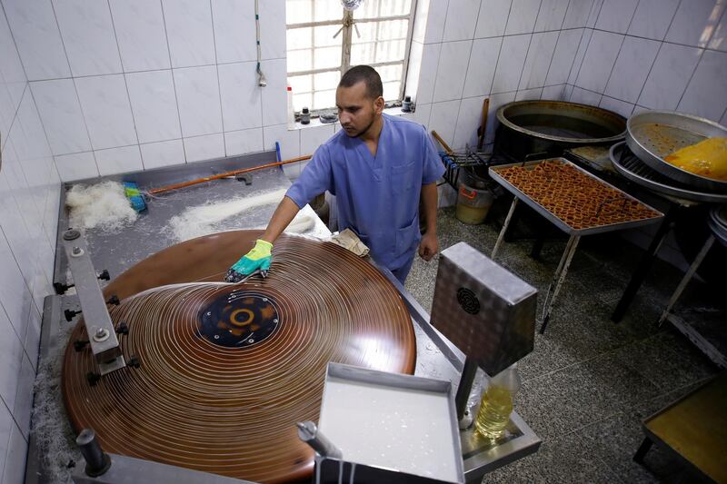 An Iraqi worker prepares sweets for sale during the last days of Ramadan at a shop in Baghdad. Reuters