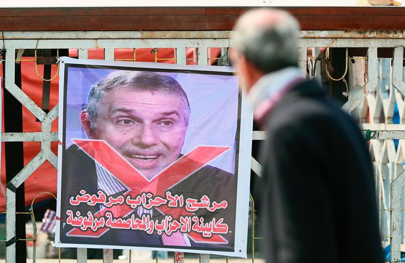 A poster of Iraq's Prime Minister-designate Mohammed Tawfiq Allawi with Arabic that reads, "The party candidate is rejected" is seen during ongoing anti-government protests in Tahrir Square, Baghdad, Iraq, Saturday, Feb. 29, 2020. (AP Photo/Hadi Mizban)