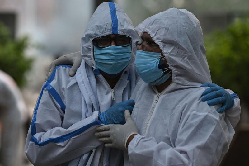 Relatives wearing Personal Protective Equipment arrive for the funeral of their relative who died due to Covid 19 coronavirus, at a crematorium in New Delhi. AFP